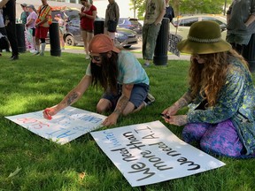 Protesters make signs.