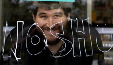 Benjamin Greenberg, owner of Yans Deli, displays the word "nosh" on his storefront window in support of Arthur’s Nosh Bar