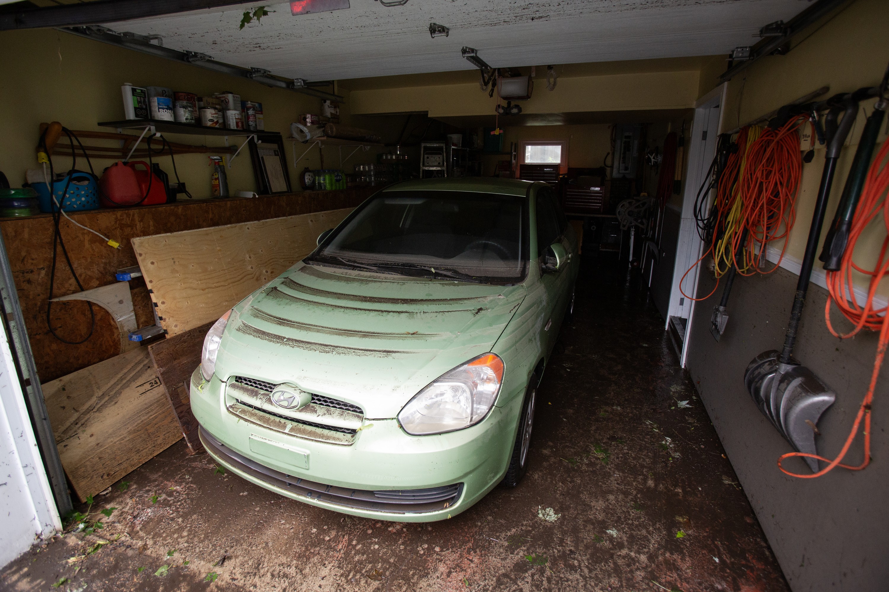 A car in a garage is marked by lines of dirt that show how high floodwaters reached.