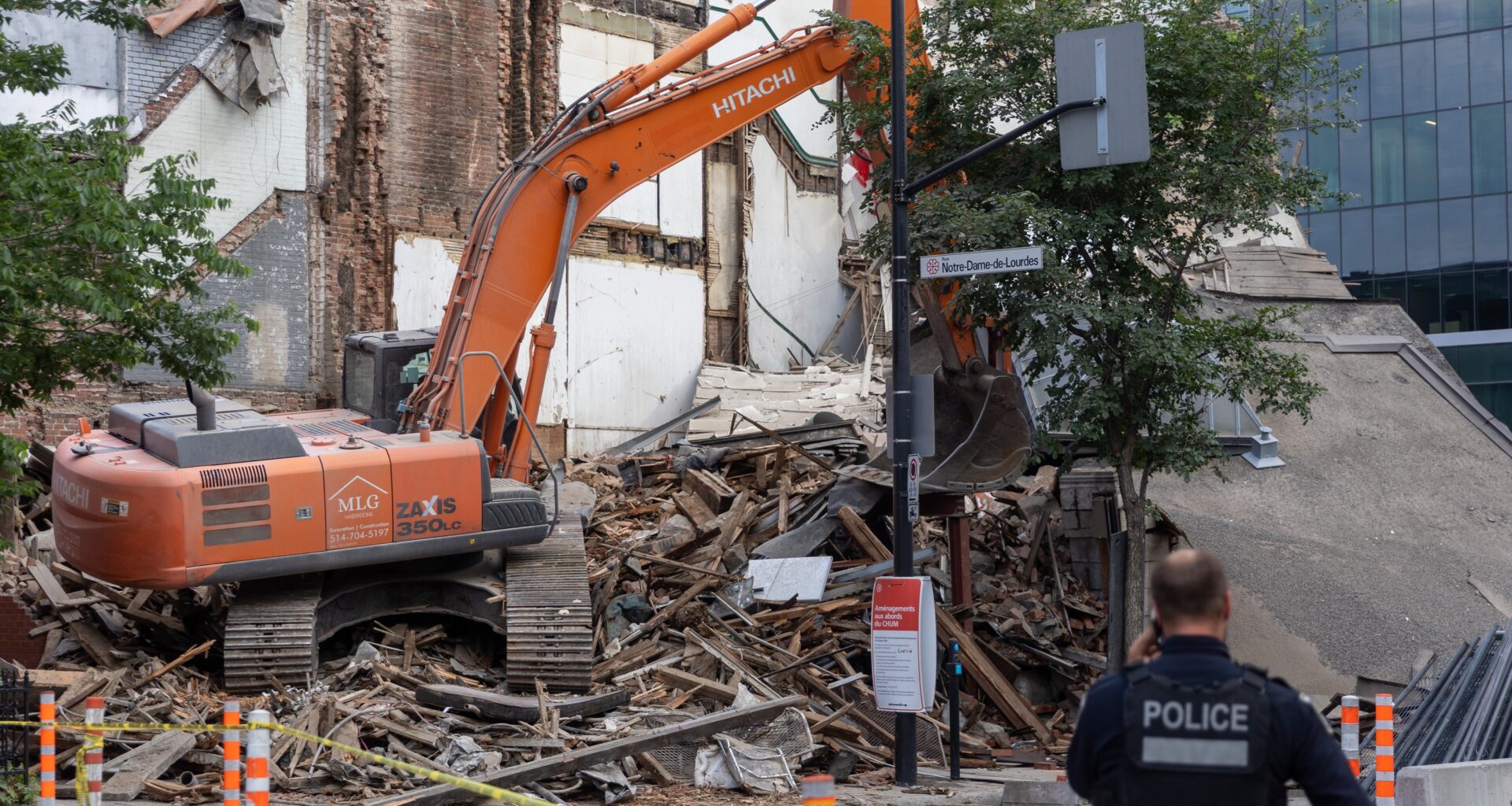 A Montreal police officer attends the scene of a building collapse on the corner of René-Lévesque Boulevard and Saint-Denis Street in Montreal on Tuesday, June 23, 2026.