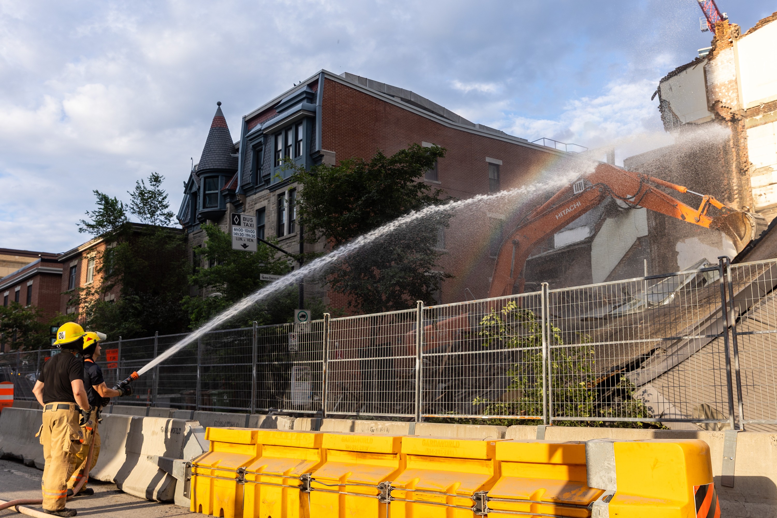 Montreal fire crews hose down the debris at the scene of a building collapse on the corner of René-Lévesque Boulevard and Saint-Denis Street in Montreal on Tuesday, June 23, 2026.