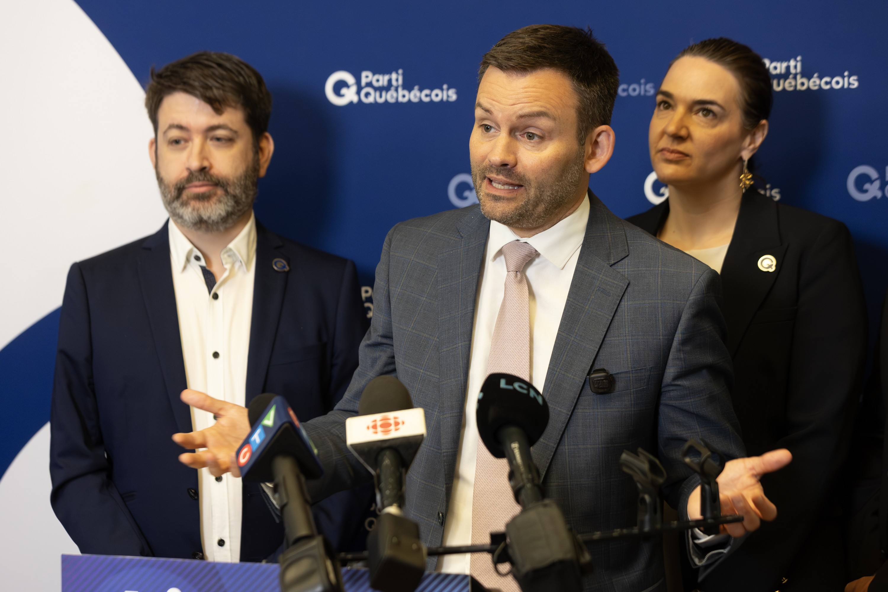 Parti Québécois Leader Paul St-Pierre Plamondon speaks about the party's blue book on independence in Montreal on Tuesday, June 23, 2026. He was joined by Jocelyn Caron, left, editor of Livre Bleu, and Terrebonne MNA Catherine Gentilcore.