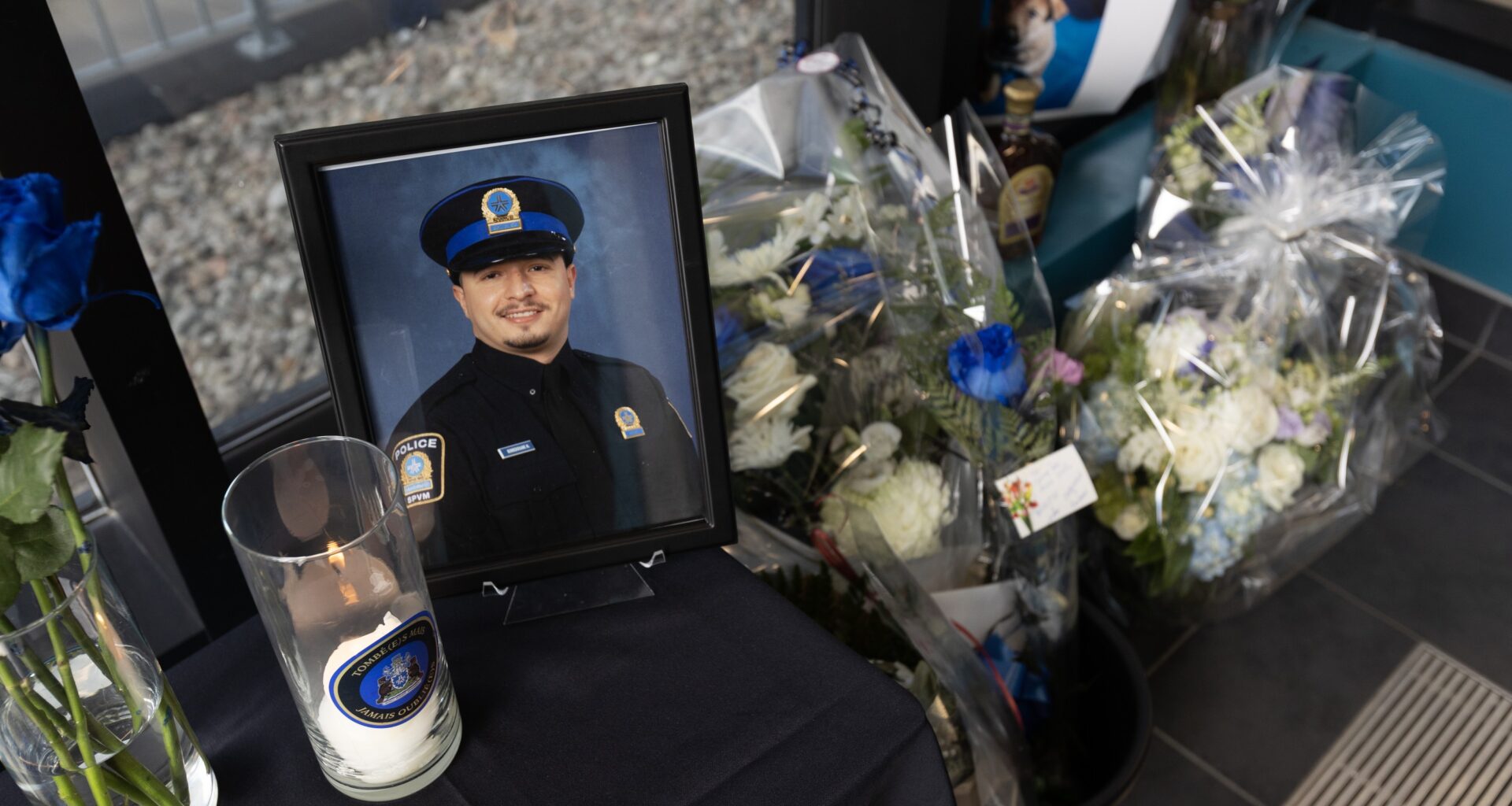 A view from above of a memorial featuring flowers, candles and a photo of a Montreal police officer.