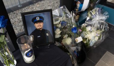 A view from above of a memorial featuring flowers, candles and a photo of a Montreal police officer.
