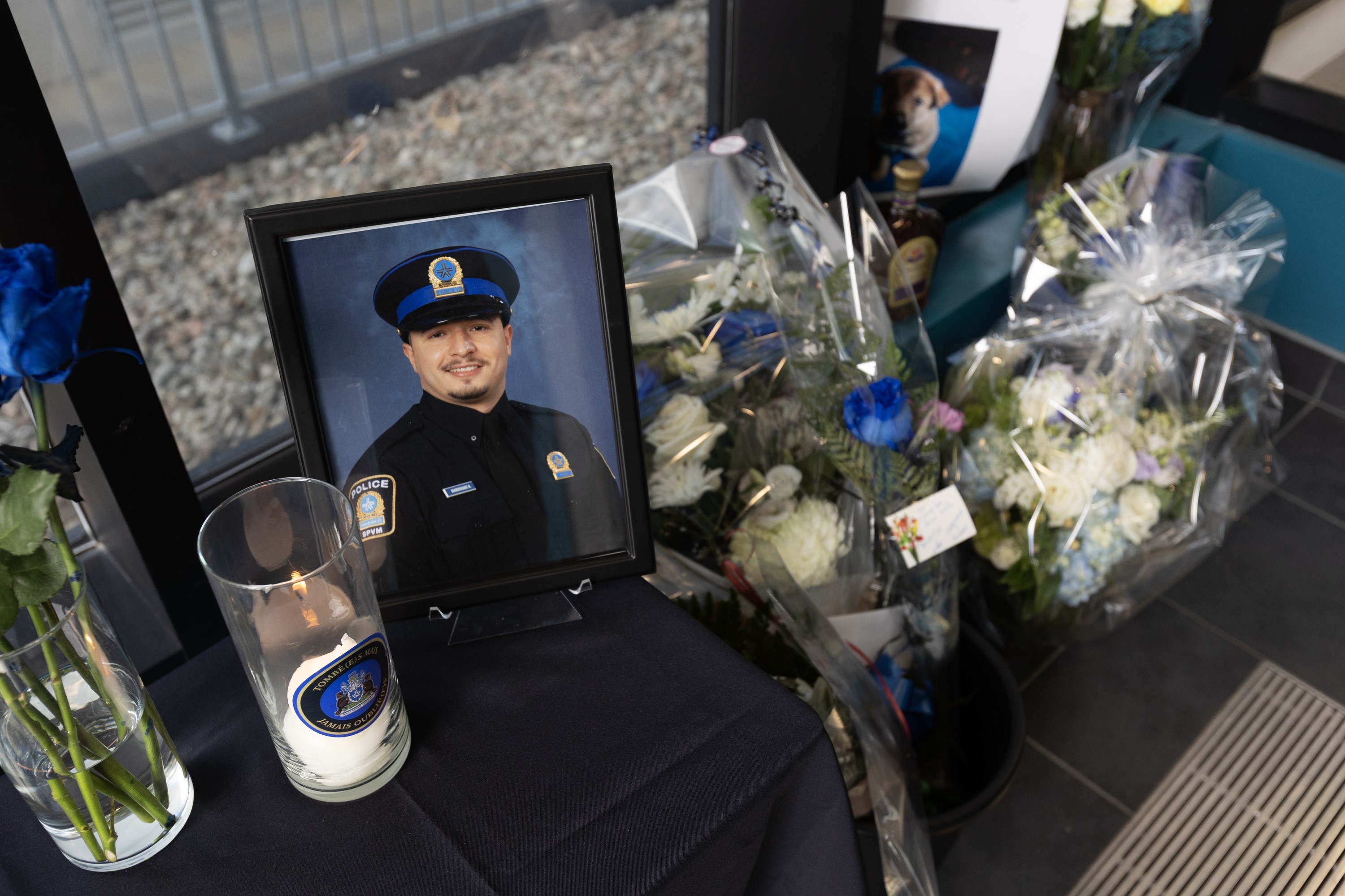 A view from above of a memorial featuring flowers, candles and a photo of a Montreal police officer.