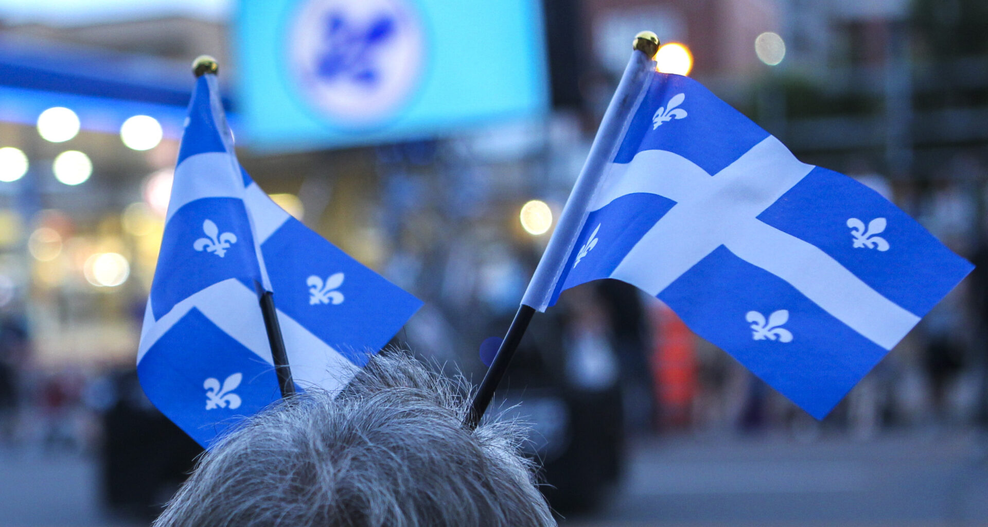 Two Quebec flags attached to someone's head.