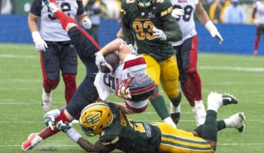 Alouettes' Travis Theis is brought down by Elks defender Malik Carney on June 20 in Edmonton.