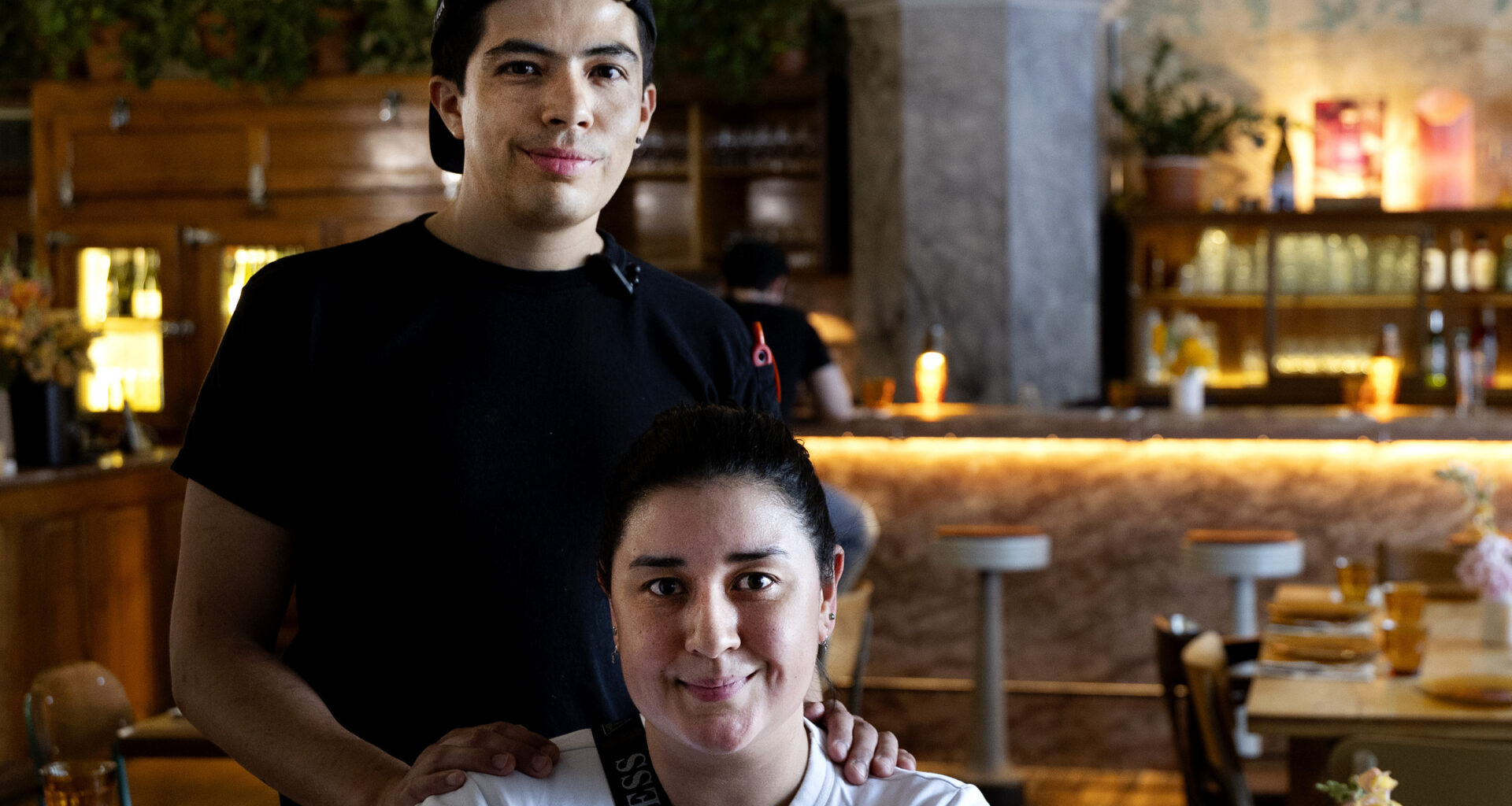 Diego Morales Cañizares and Maria Paula pose for a photo in a restaurant dining room.