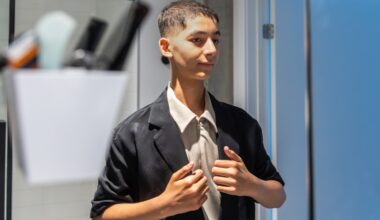 Adam Beaury, at home on Friday, June 19, preparing for his prom. He is wearing a light-coloured top and pants and a dark jacket. 