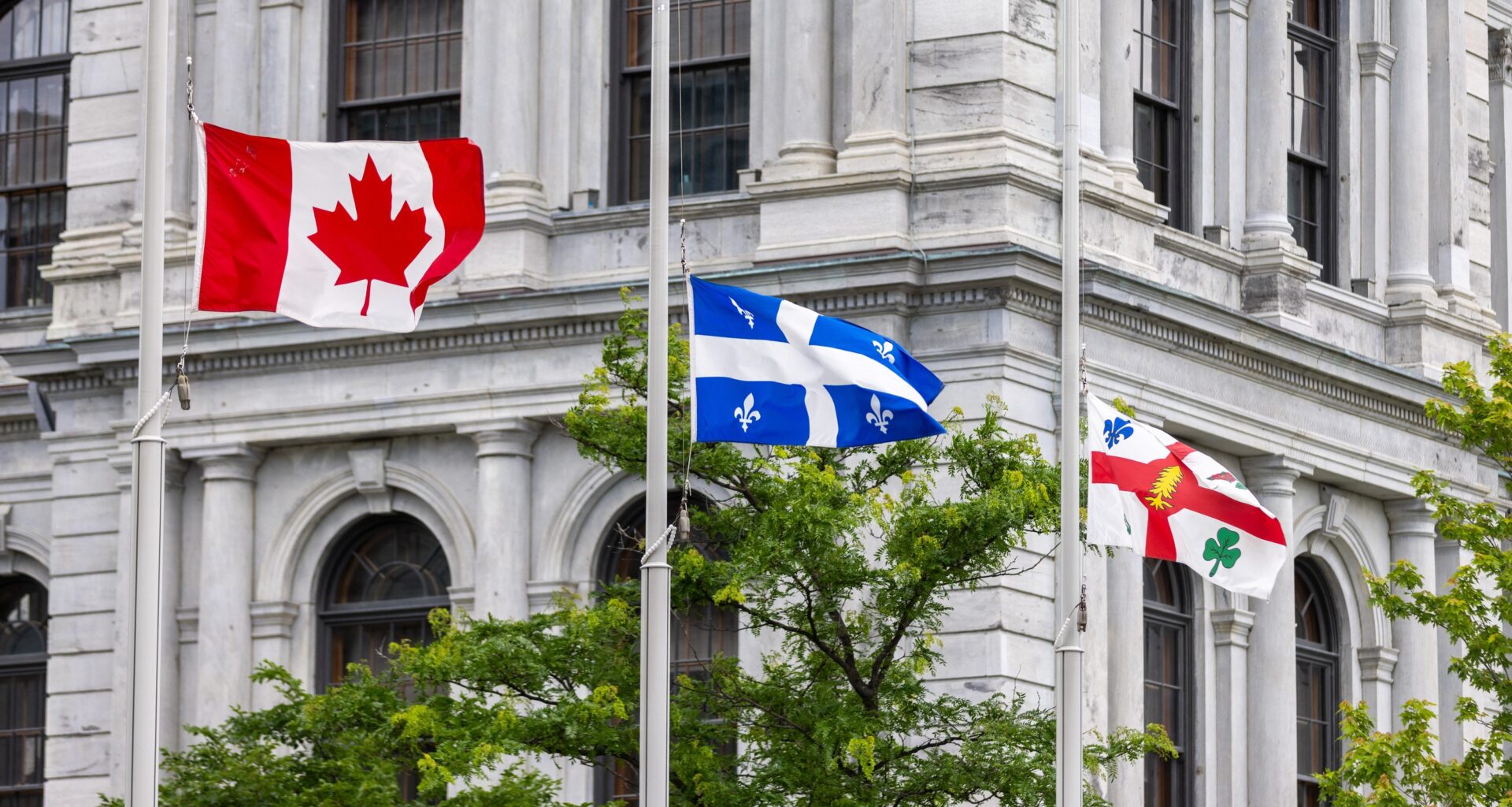 Canadian, Quebec and Montreal flags fly at half mast outside Montreal city hall