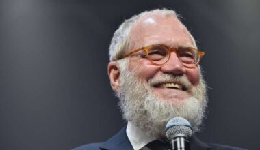 David Letterman grins as he holds a microphone