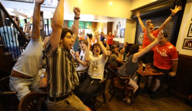 Fans at teh Burgundy Lion pub jump for joy after Canada's late goal against South Africa.