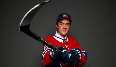 Cooper Cleaves poses for a portrait, with hockey stick extended toward the camera, after being selected by the Montreal Canadiens in the NHL Draft.