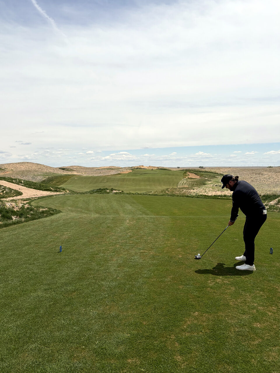 A left-handed golfer tees up a shot at the 12th hole at Rodeo Dunes in Roggen, Colorado