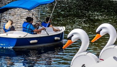 A group of boaters take a ride on the water under the watchful eyes of a oair of duck boats.