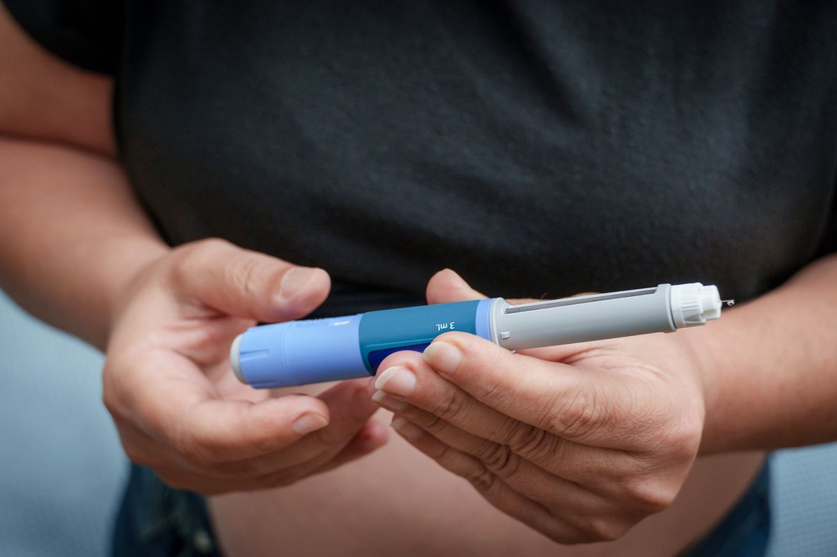 Person's hands holding an insulin pen for diabetes treatment