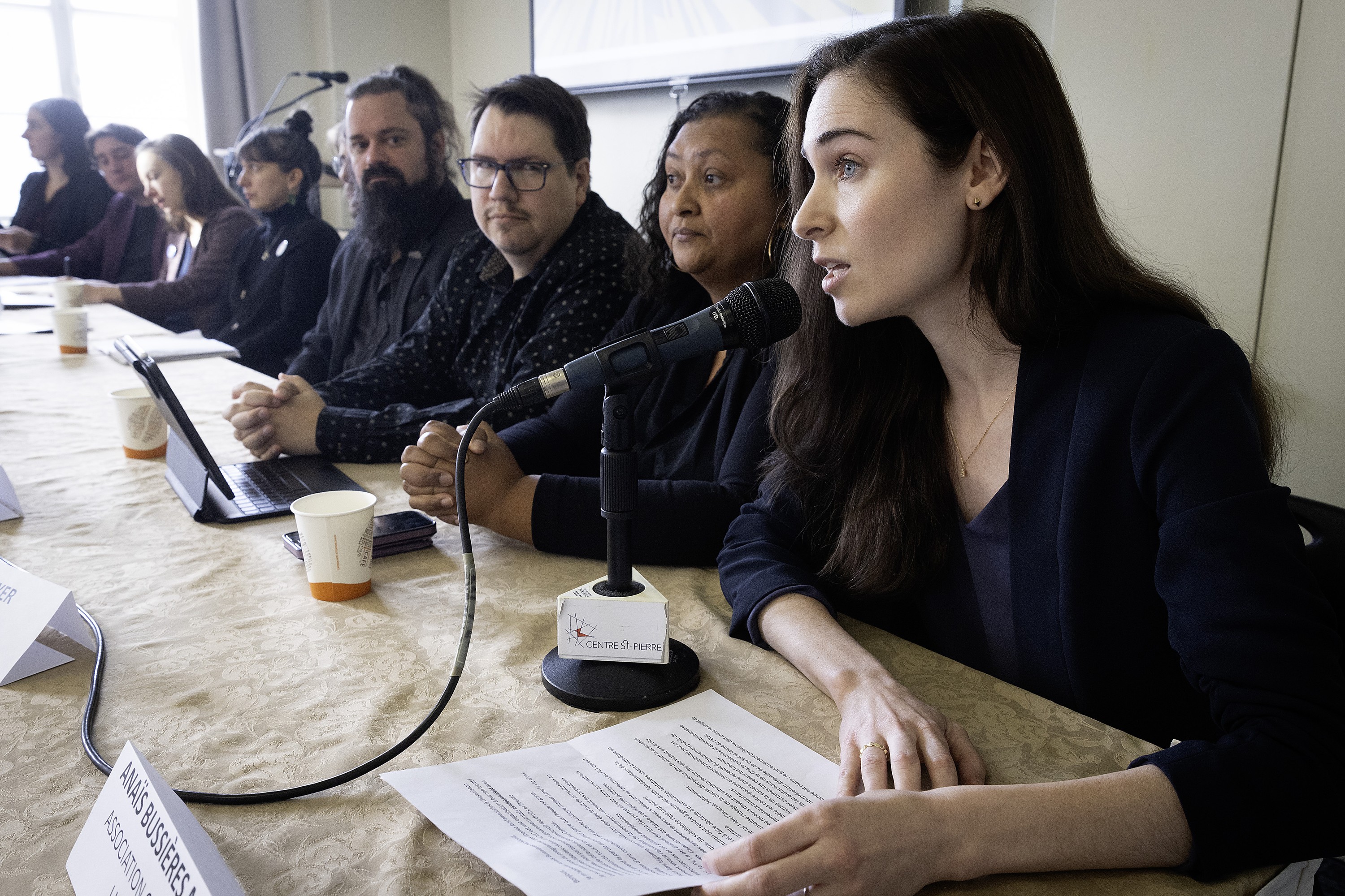 People sit at a table at a press conference