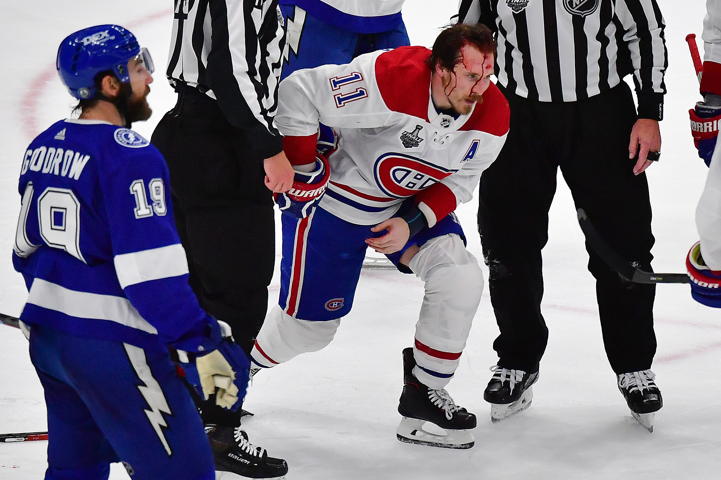 Brendan Gallagher skates on the ice with a bloodied face.