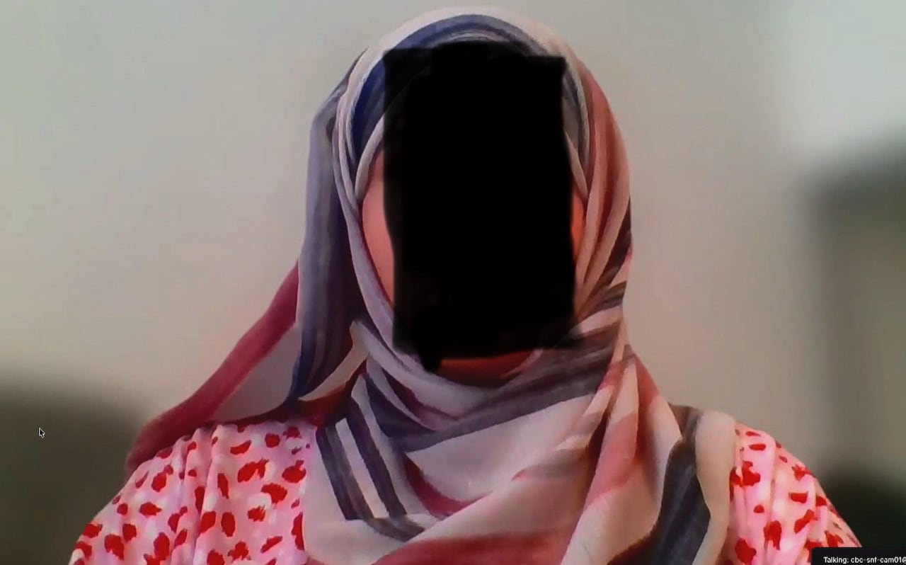 A woman wearing a colourful hajib. her faced is obscured to protect her identity.