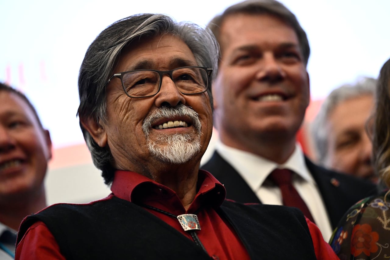 A man with glasses smiling