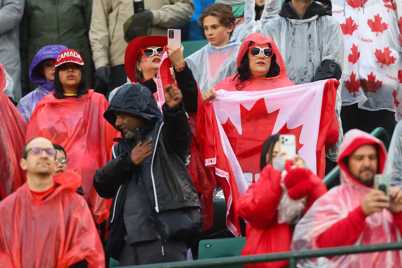 People stand in the rain wearing ponchos.