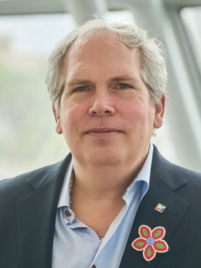 a man in a suits poses for a portrait