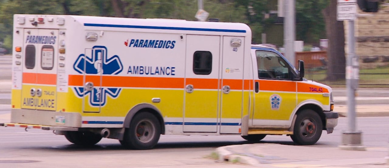 An ambulance is shown driving on a city road.