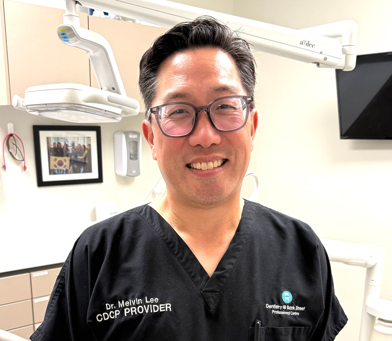 Dentist in his exam room smiling
