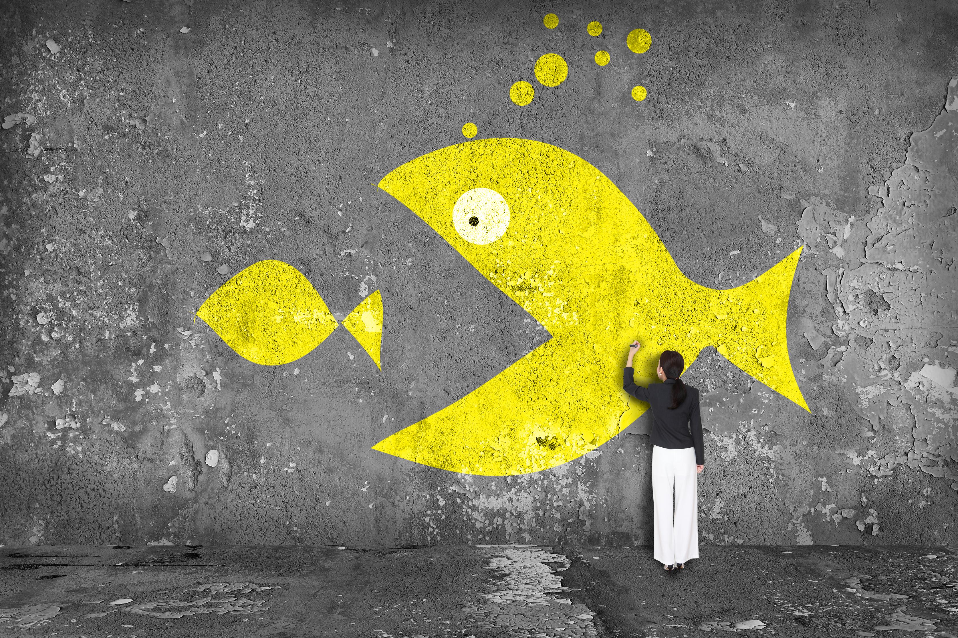 A person drawing a picture of a large fish getting ready to swallow a smaller fish.