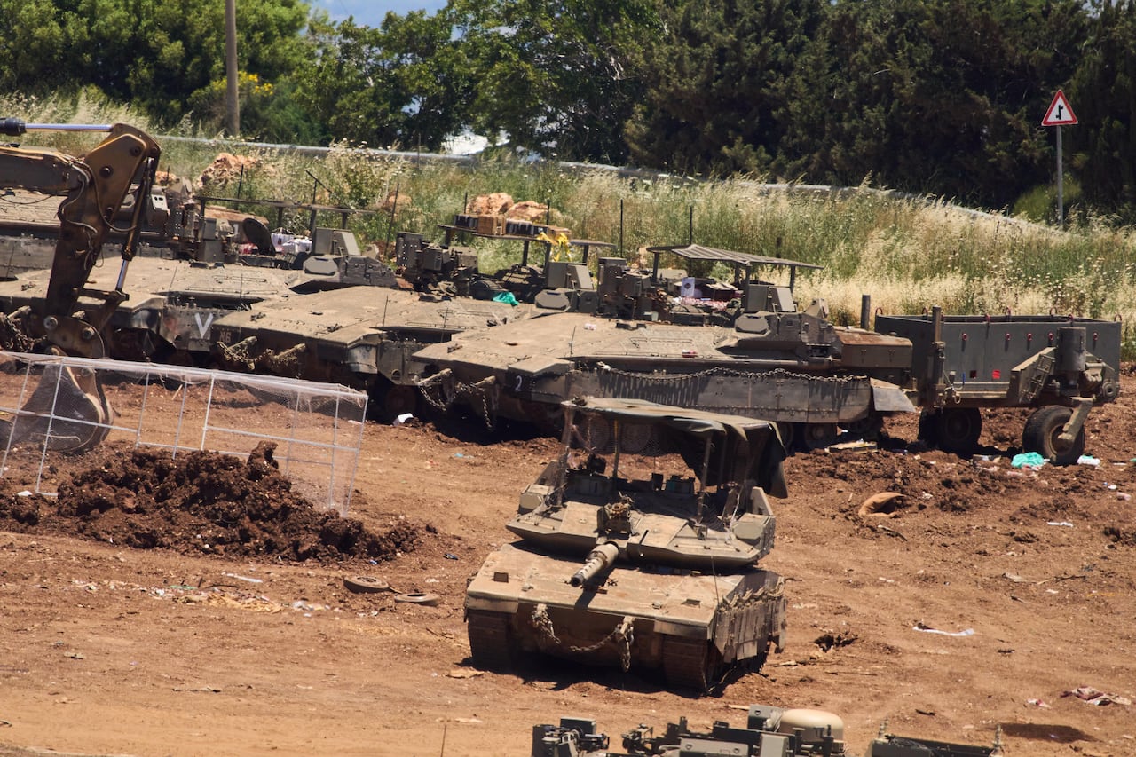 Several tanks are shown on a patch of dirt.