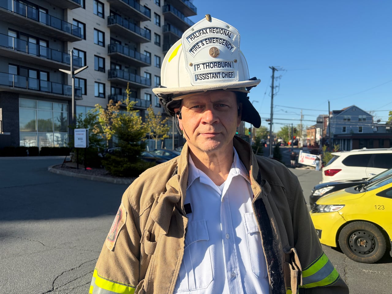 A firefighter stands near an apartment building