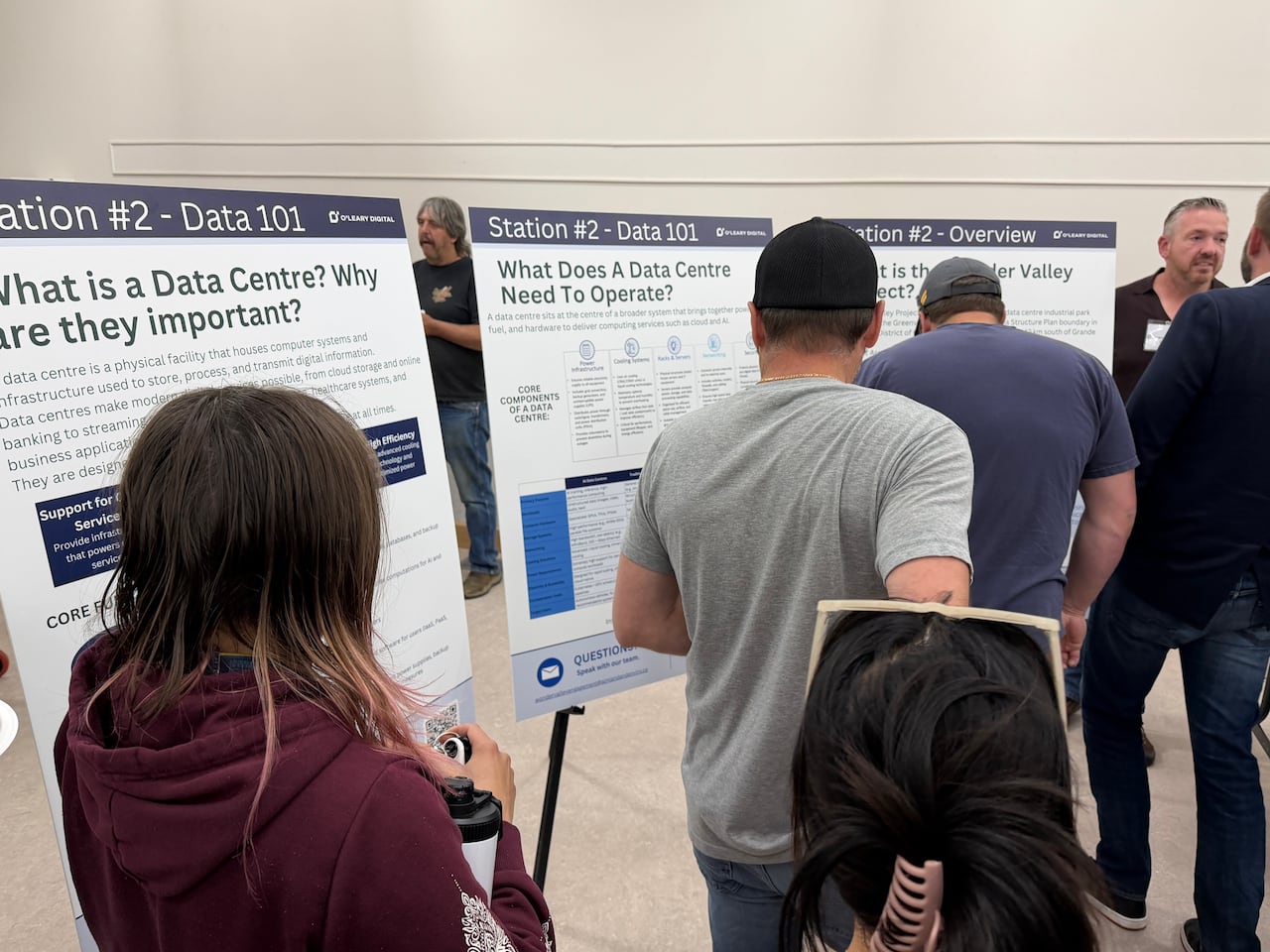 People stand in a room in front of poster boards.