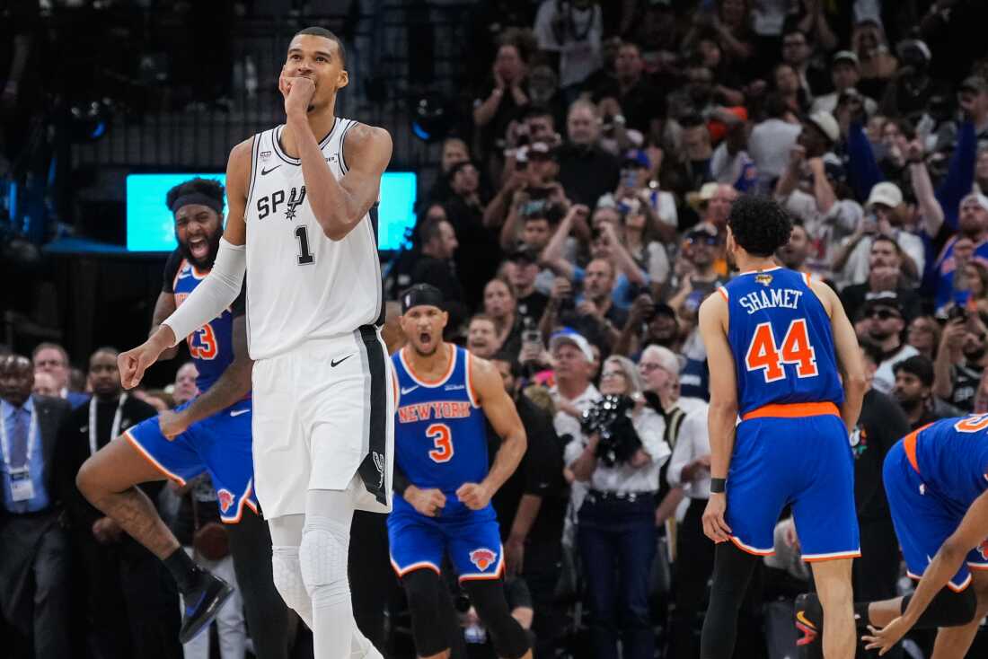 San Antonio Spurs forward Victor Wembanyama walks off the court as time expires during the second half of Game 2 of the NBA Finals basketball series as New York Knicks guard Landry Shamet (44), guard Josh Hart (3), and center Mitchell Robinson (23) celebrate, Friday, June 5, 2026, in San Antonio.