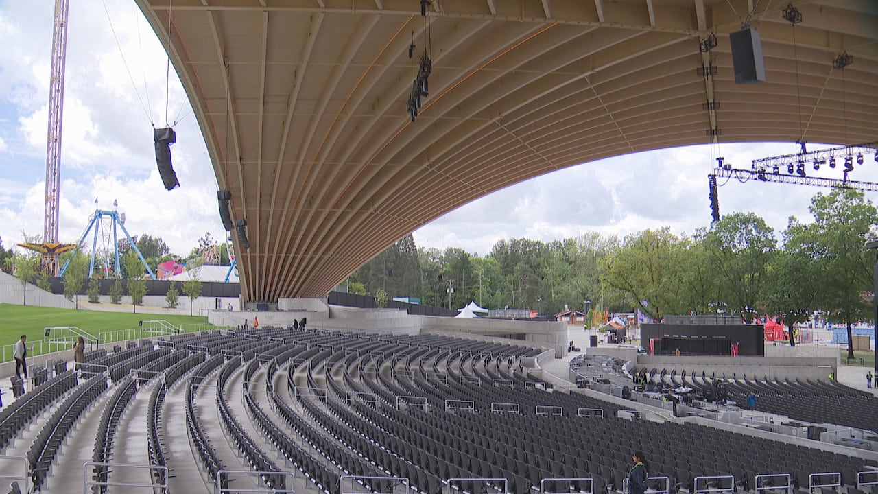 Rows of seating under a curved wooden roof.