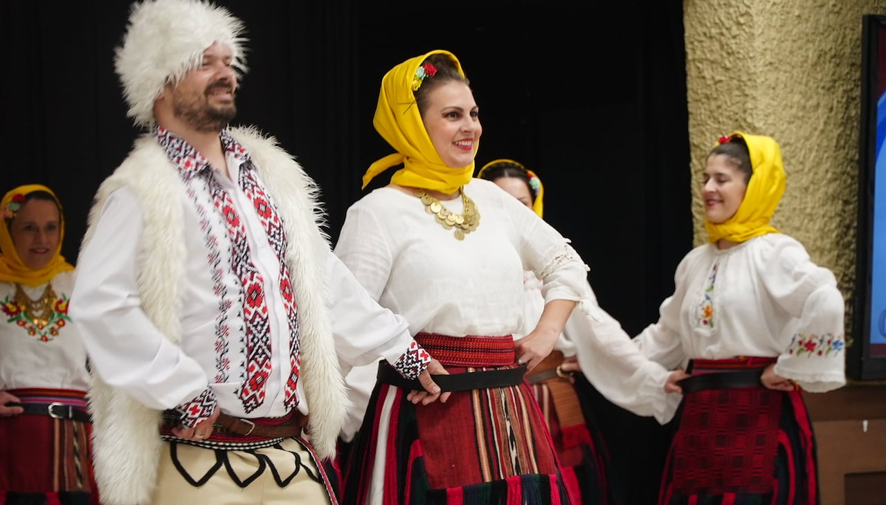 Folk dancers in traditional clothing dancing.