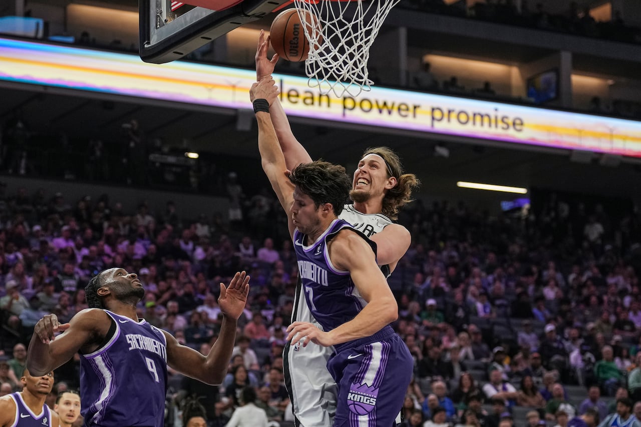 Two men in the air as one takes a shot in basketball