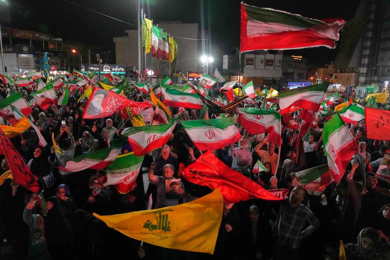 Demonstrators wave flags at an outdoor rally.