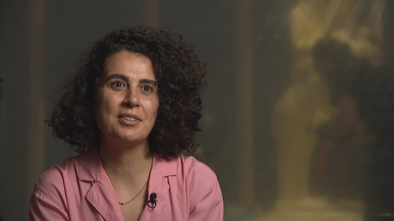 A woman with dark curly hair.