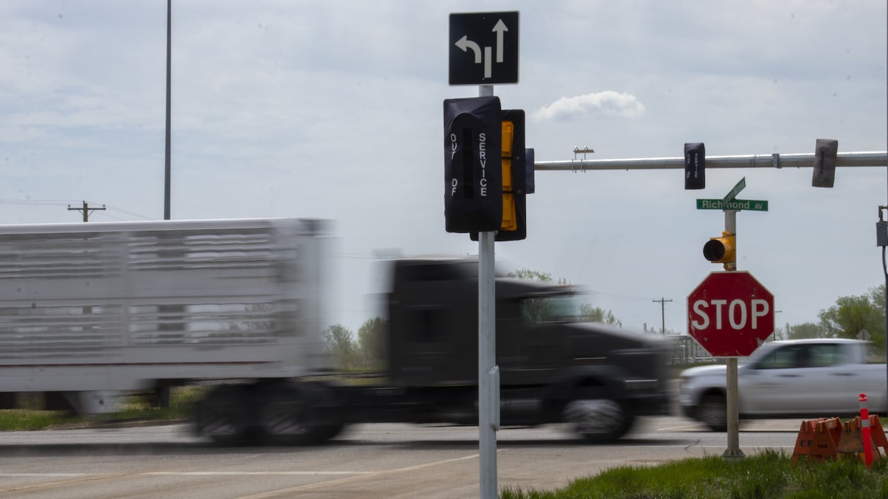 Semi's drive though a highway intersection.