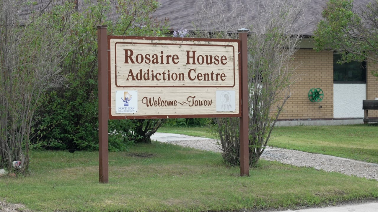 A sign stands in front of a building.
