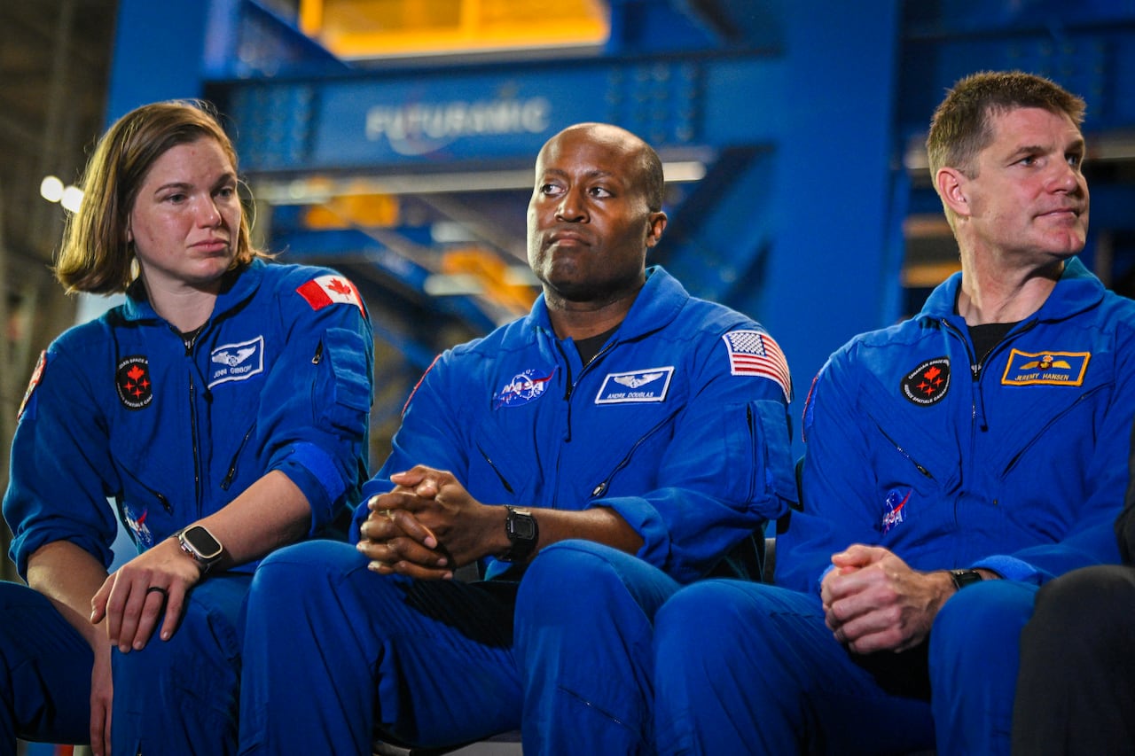 Astronaut Andre Douglas sits between two Canadian astronauts.