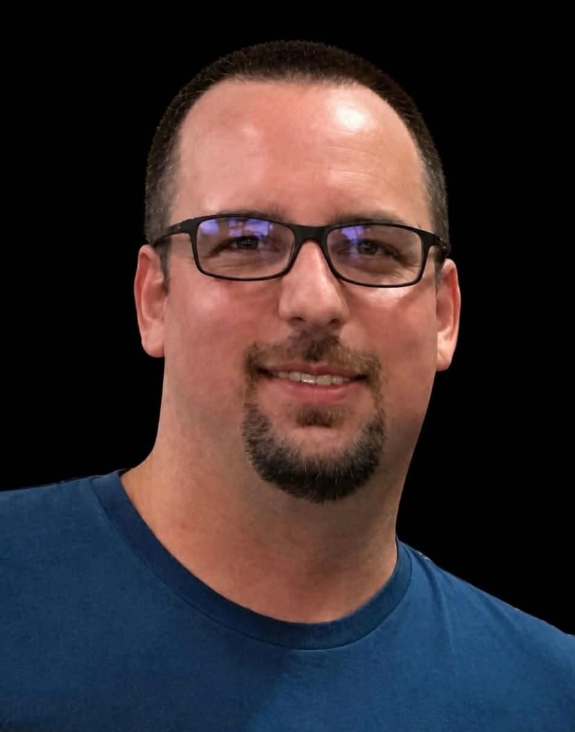 man in blue sweater poses for camera
