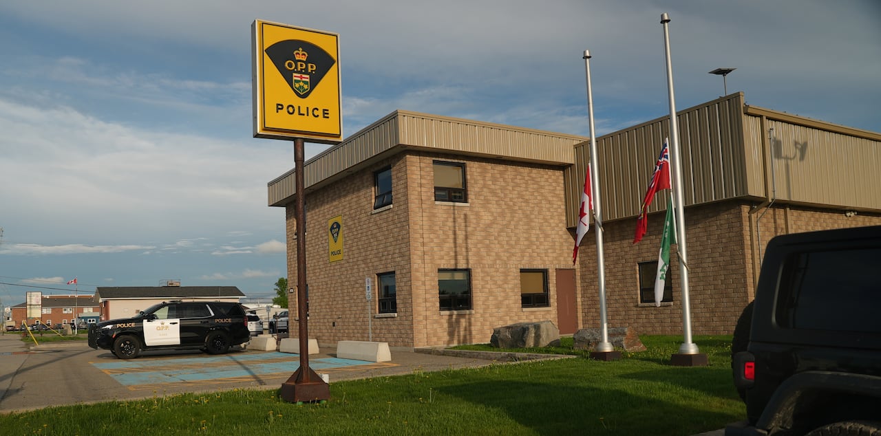 Flags can be seen flying at half-mast at the Ontario Provincial Police detachment in Hearst, Ont.
