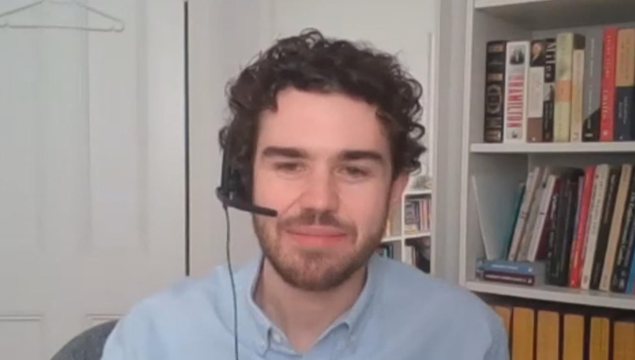 Man in blue collared shirt with curly black hair.