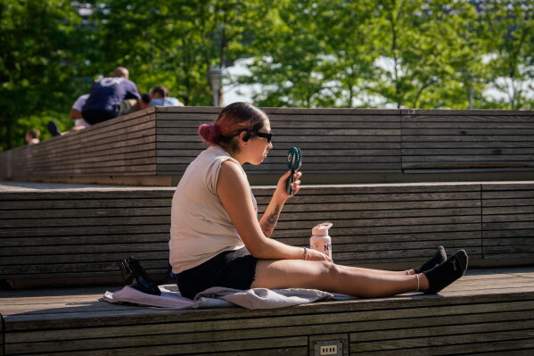 A person uses a fan during a heat advisory in the Brooklyn borough of New York, May 19, 2026. (AP Photo/Adam Gray, File)