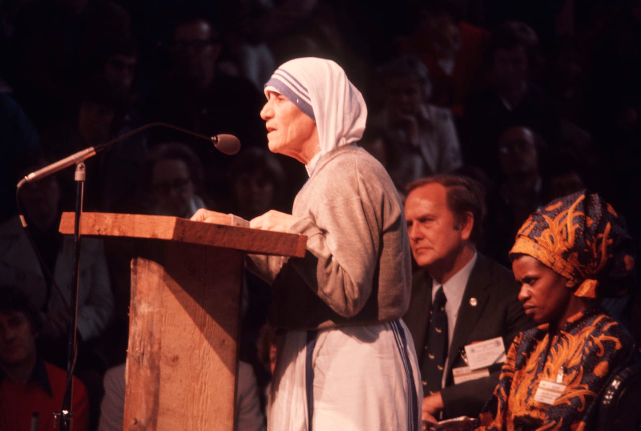 Mother Teresa speaks at a podium.
