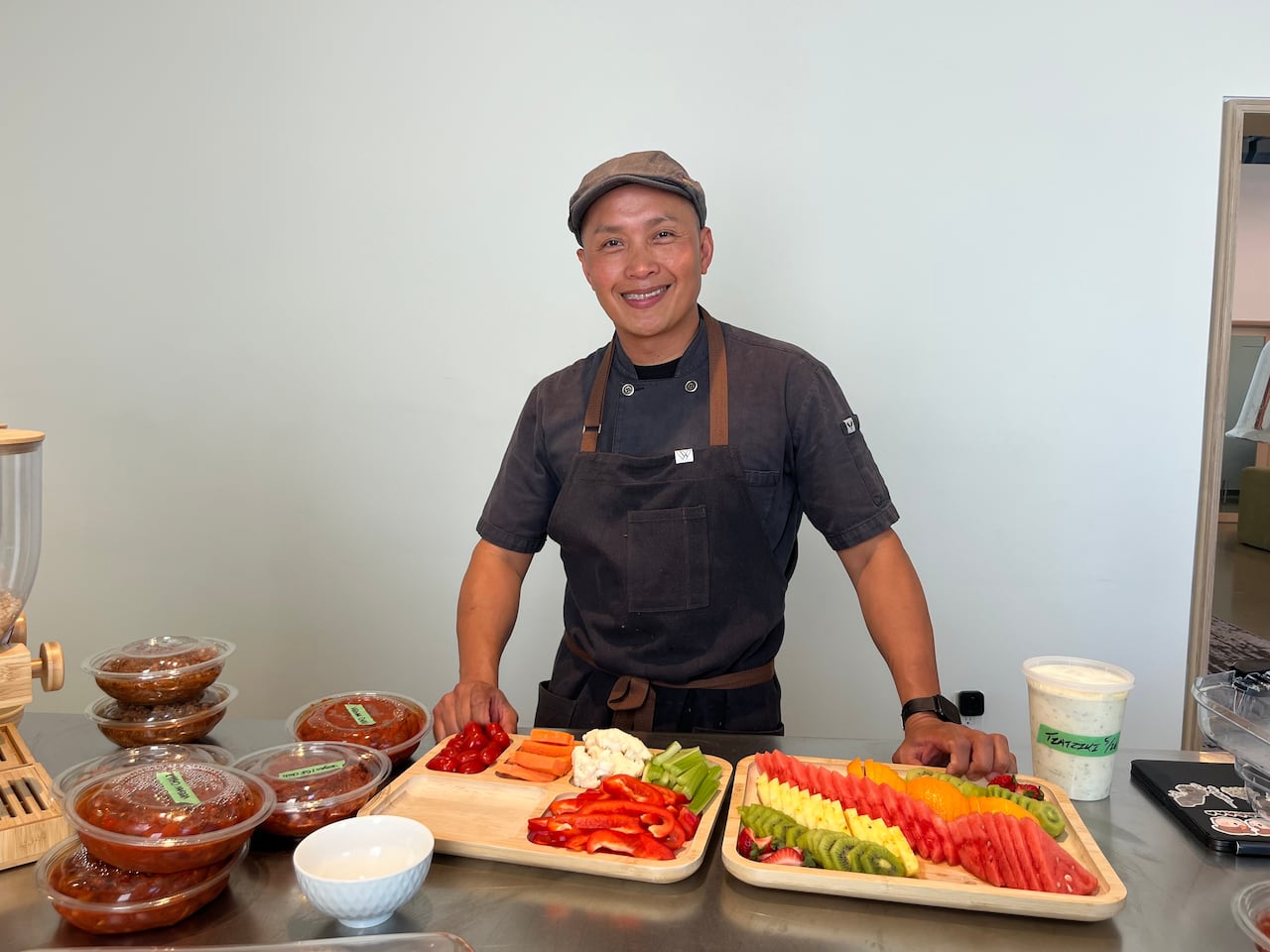 Man with veggie trays and bowls of chili