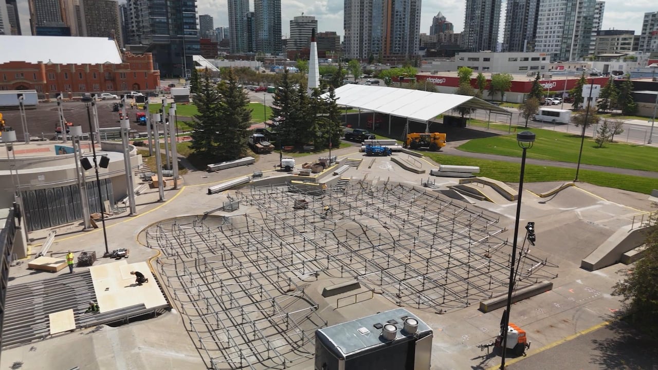 A photo of a skatepark shot from above. Scaffolding is set up inside a large skatepark bowl.