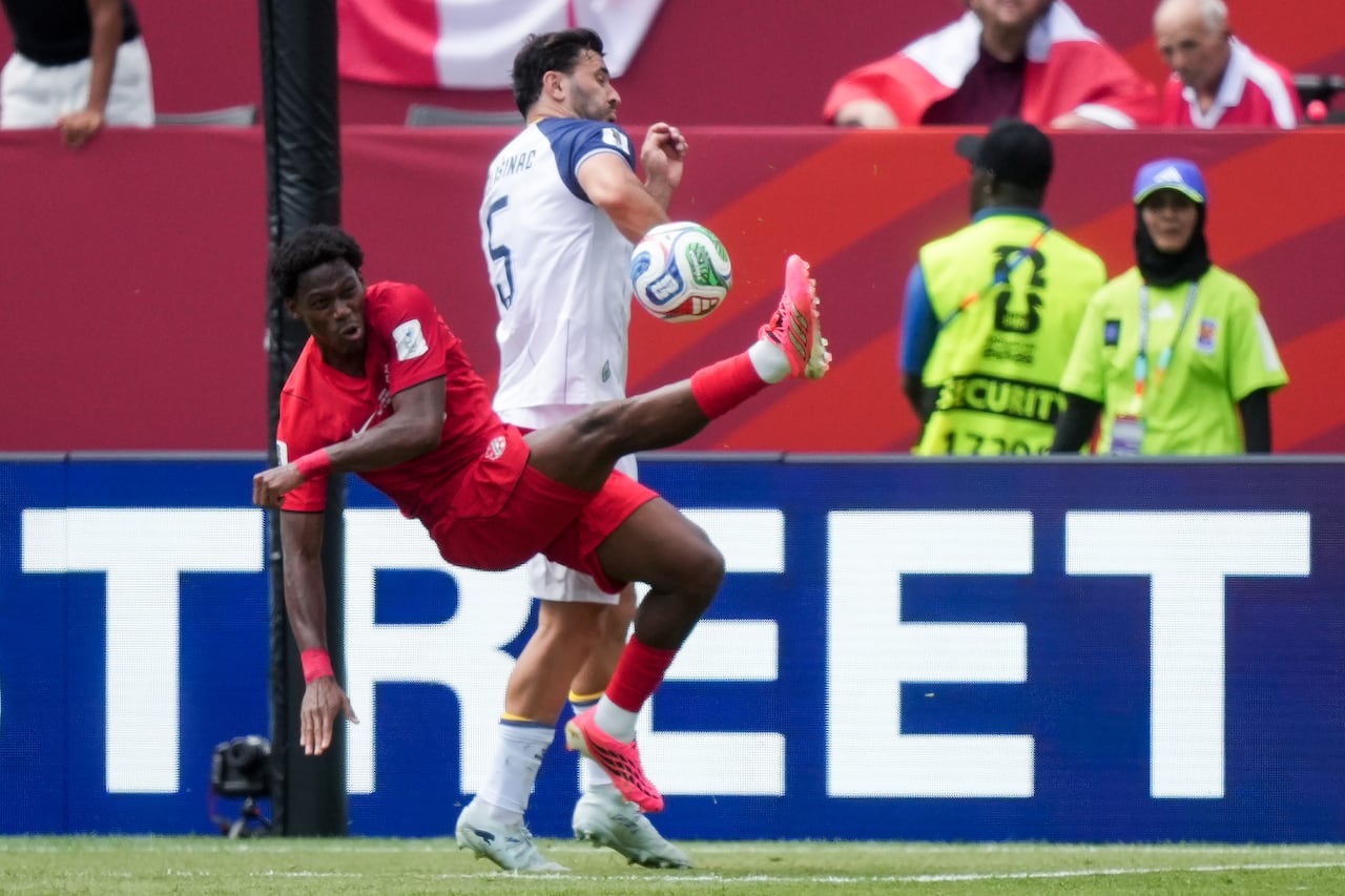 A soccer player tries to kick the ball.