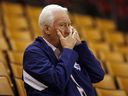 Former Toronto Maple Leafs GM Cliff Fletcher covers his mouth while talking on the phone.